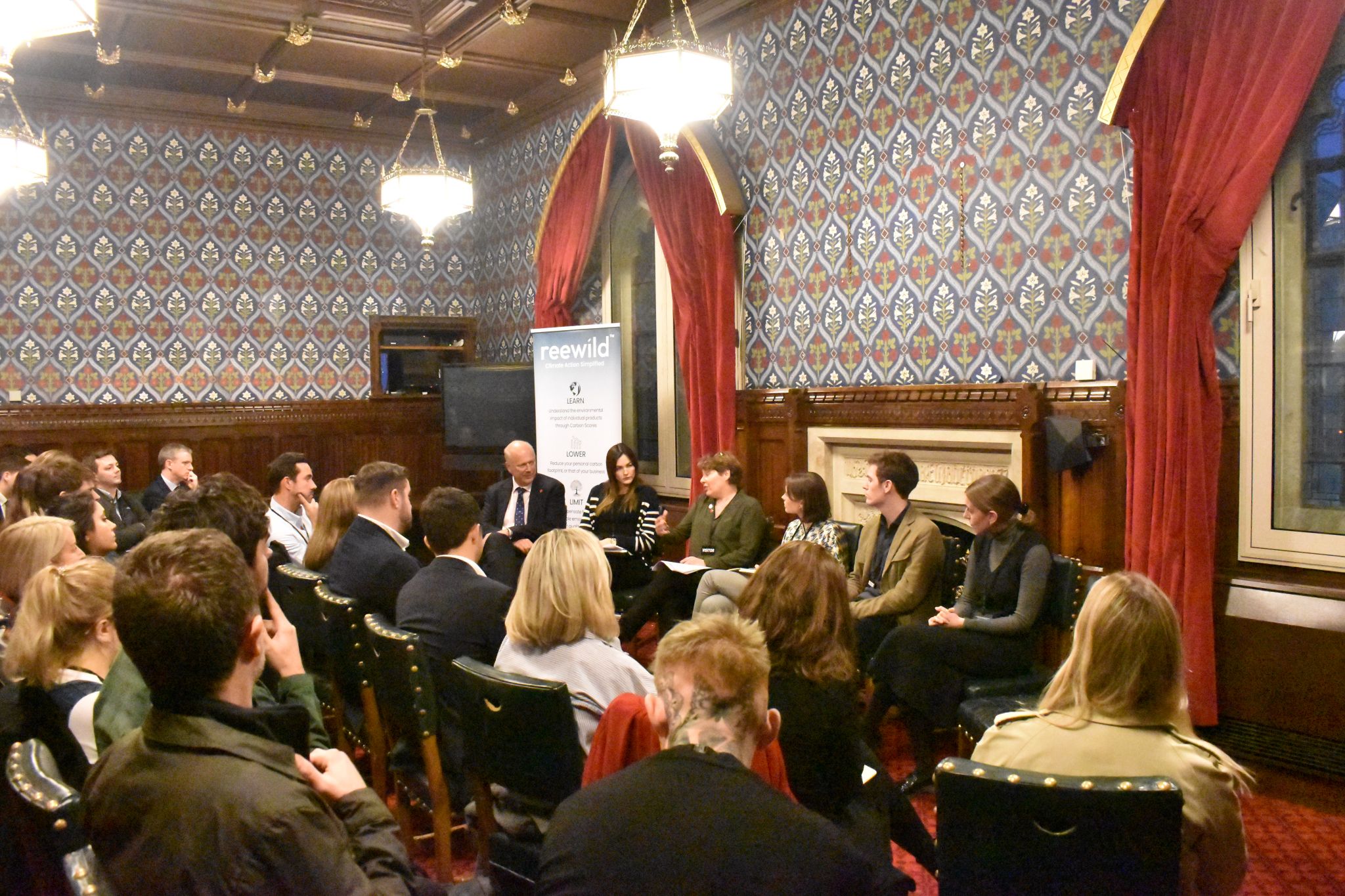 Wider view of the panel discussion at Parliament with Reewild banner